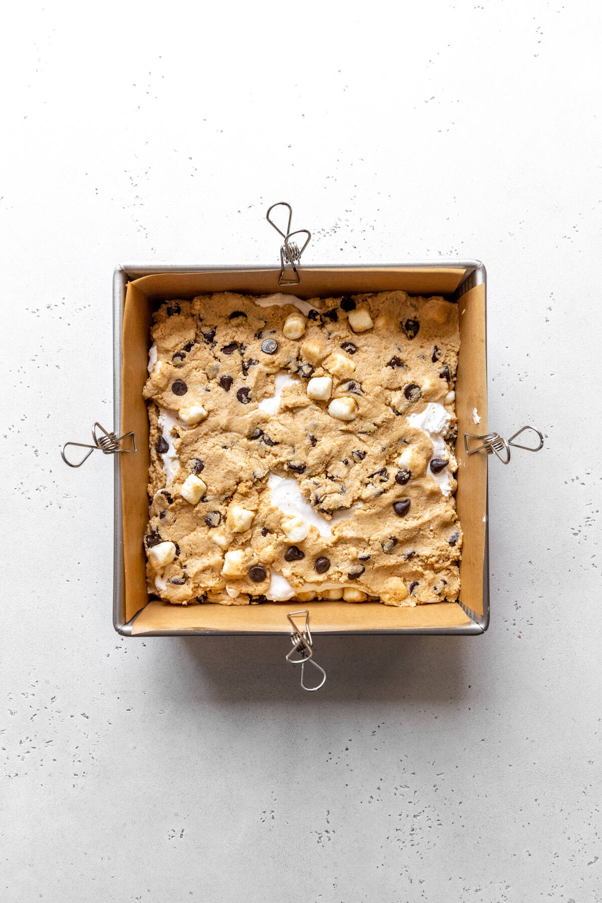 Unbaked s'mores bars in a square pan.