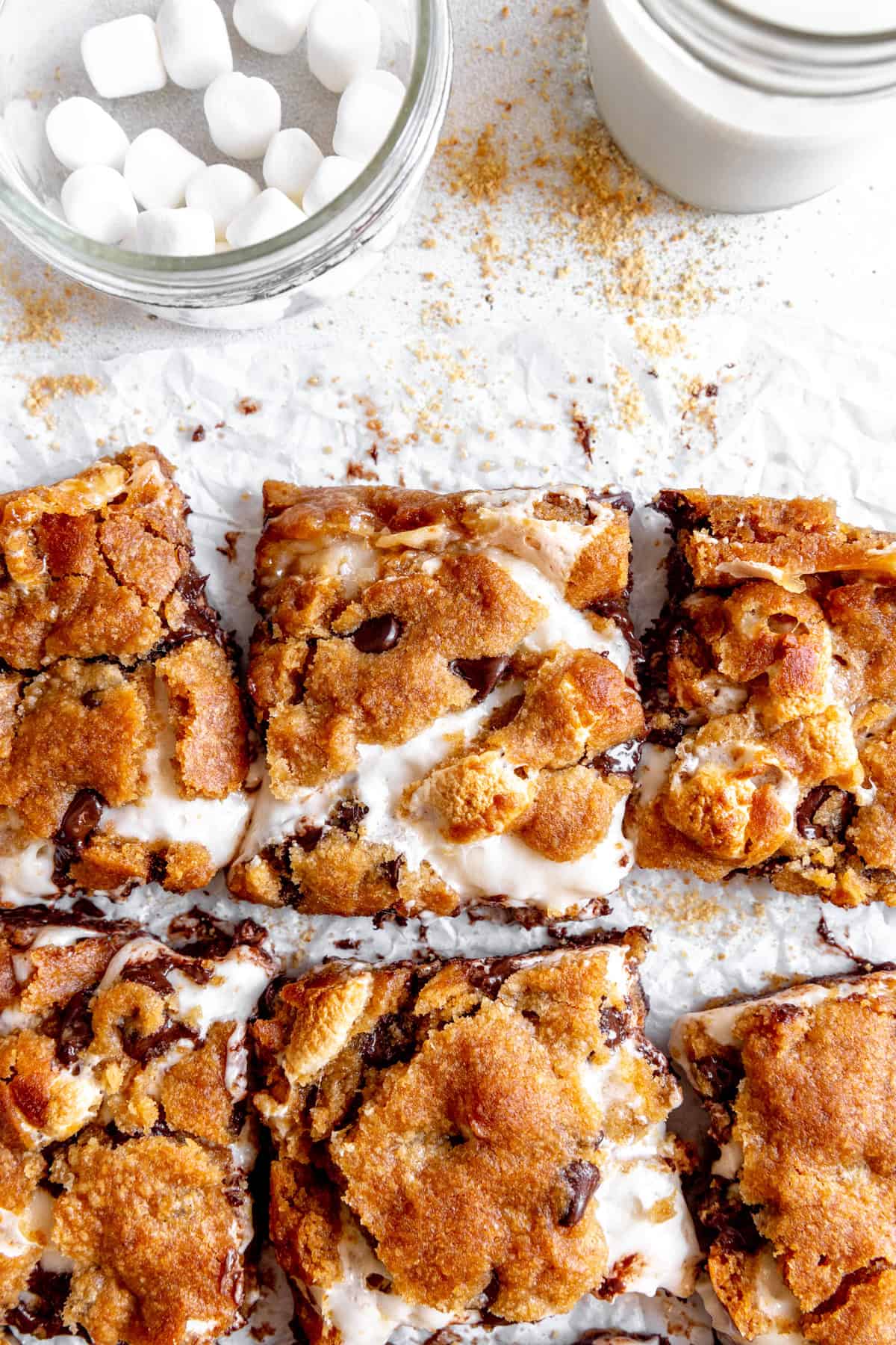 Gooey s'mores bars, a cup of marshmallows and a cup of milk.