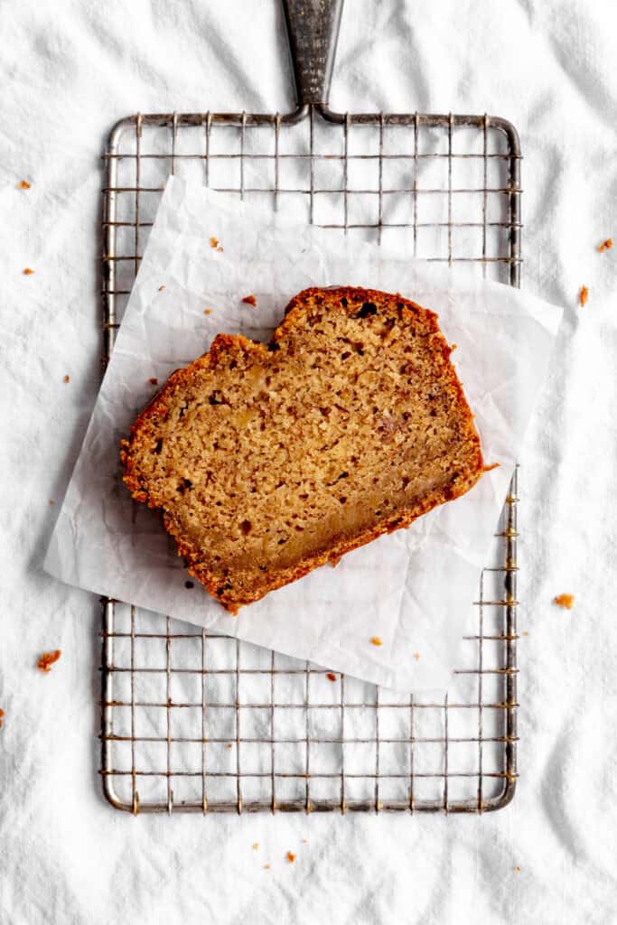 Slice of banana bread on a wire rack.