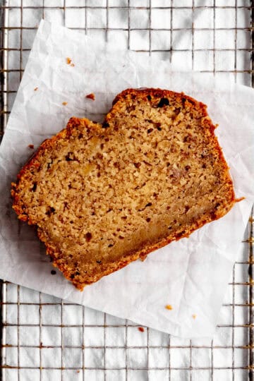 Slice of banana bread on a wire rack.
