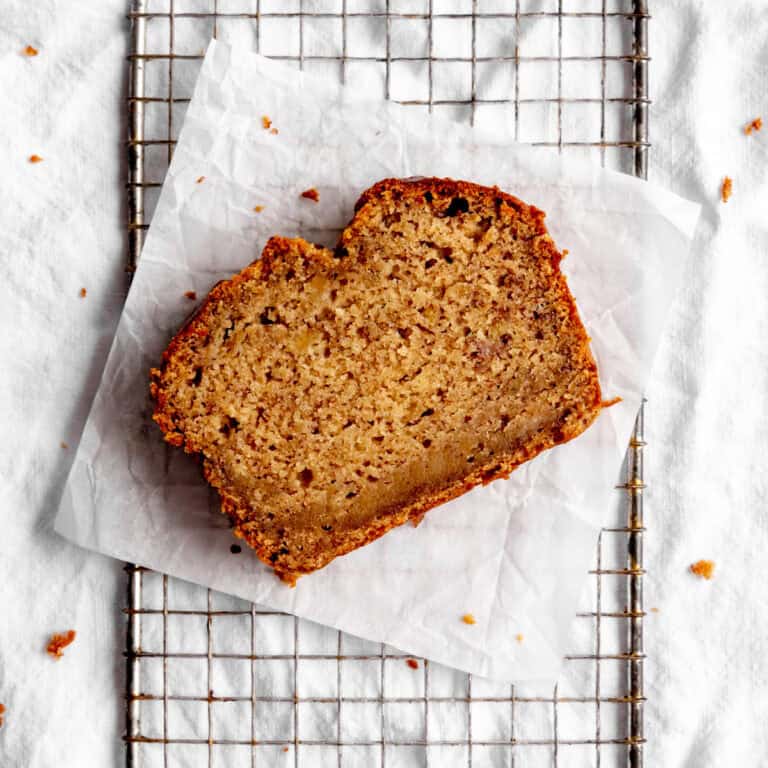 Slice of banana bread on a wire rack.