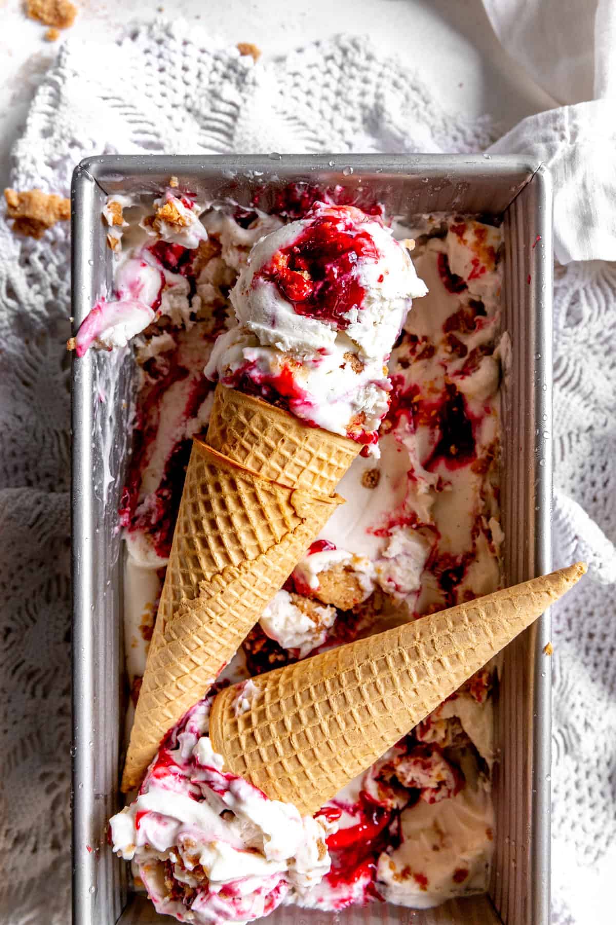 Sugar cones topped with scoops of blackberry cobbler ice cream.