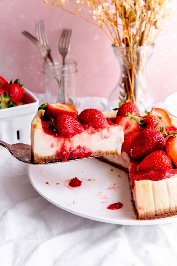 Spatula pulling out a slice of cheesecake.