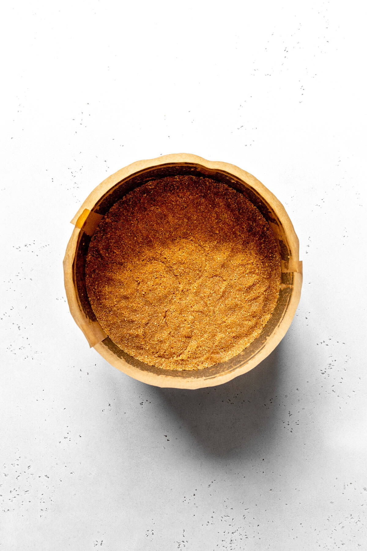 Unbaked graham cracker crust in a circular pan.