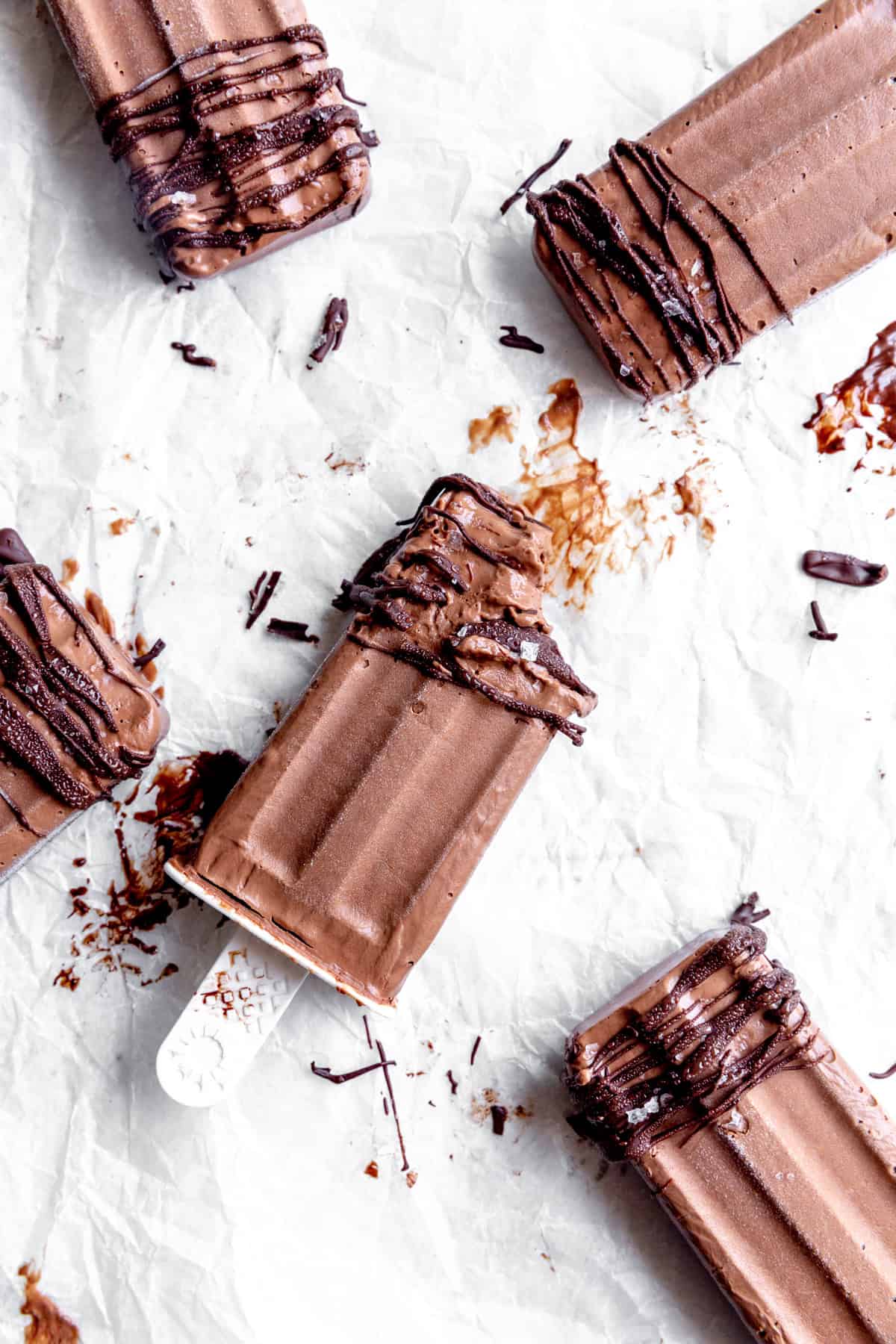 Melty fudge pops laying on a white surface.