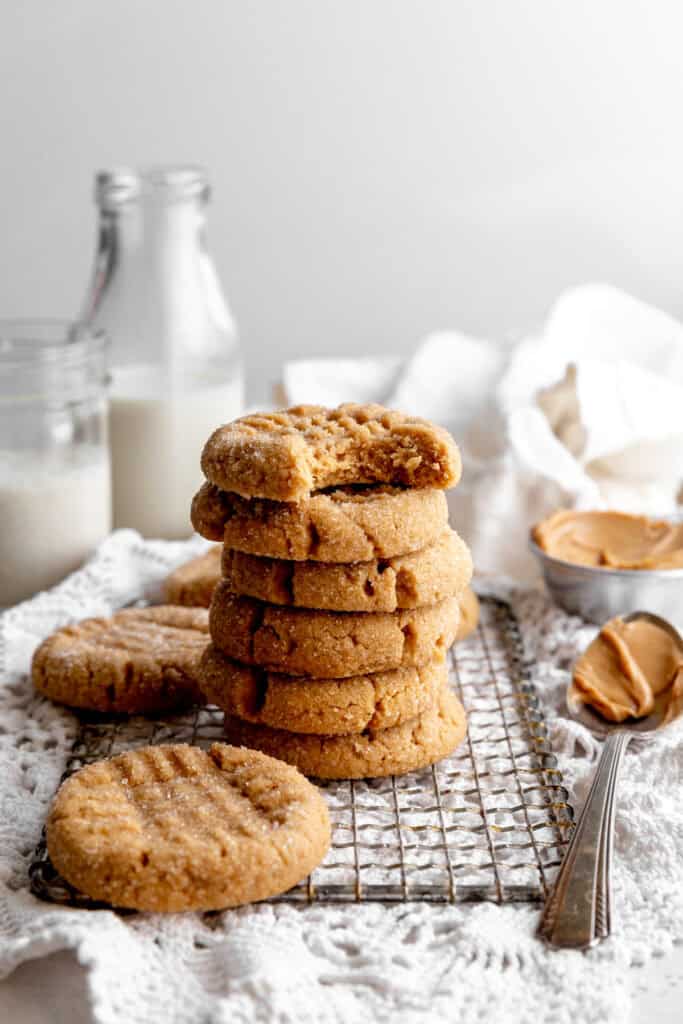 Stack of peanut butter cookies and a jug of milk.