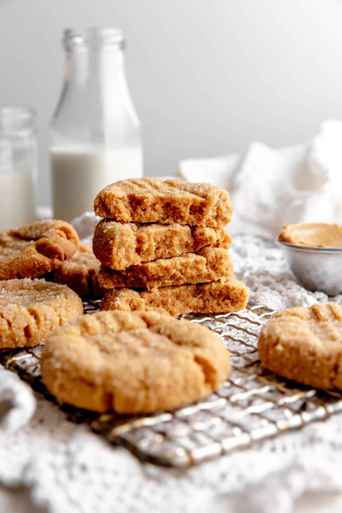 Stack of peanut butter cookie halves and a white linen napkin.