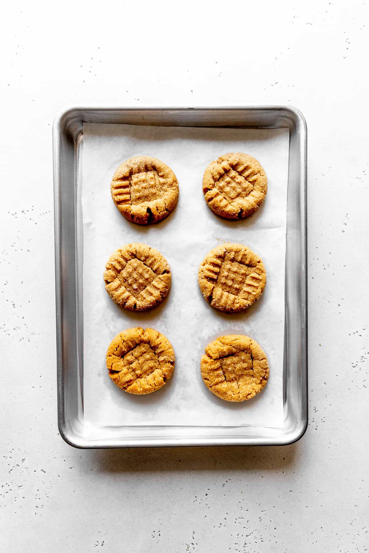 Baked peanut butter cookies on a baking sheet.