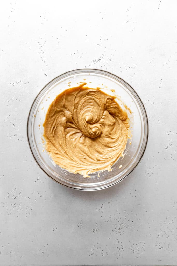 Creamed butter, sugar and peanut butter in a glass bowl.