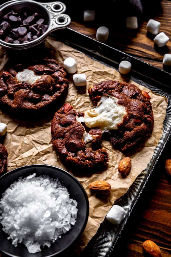 Rocky road cookie being pulled apart on a baking sheet.