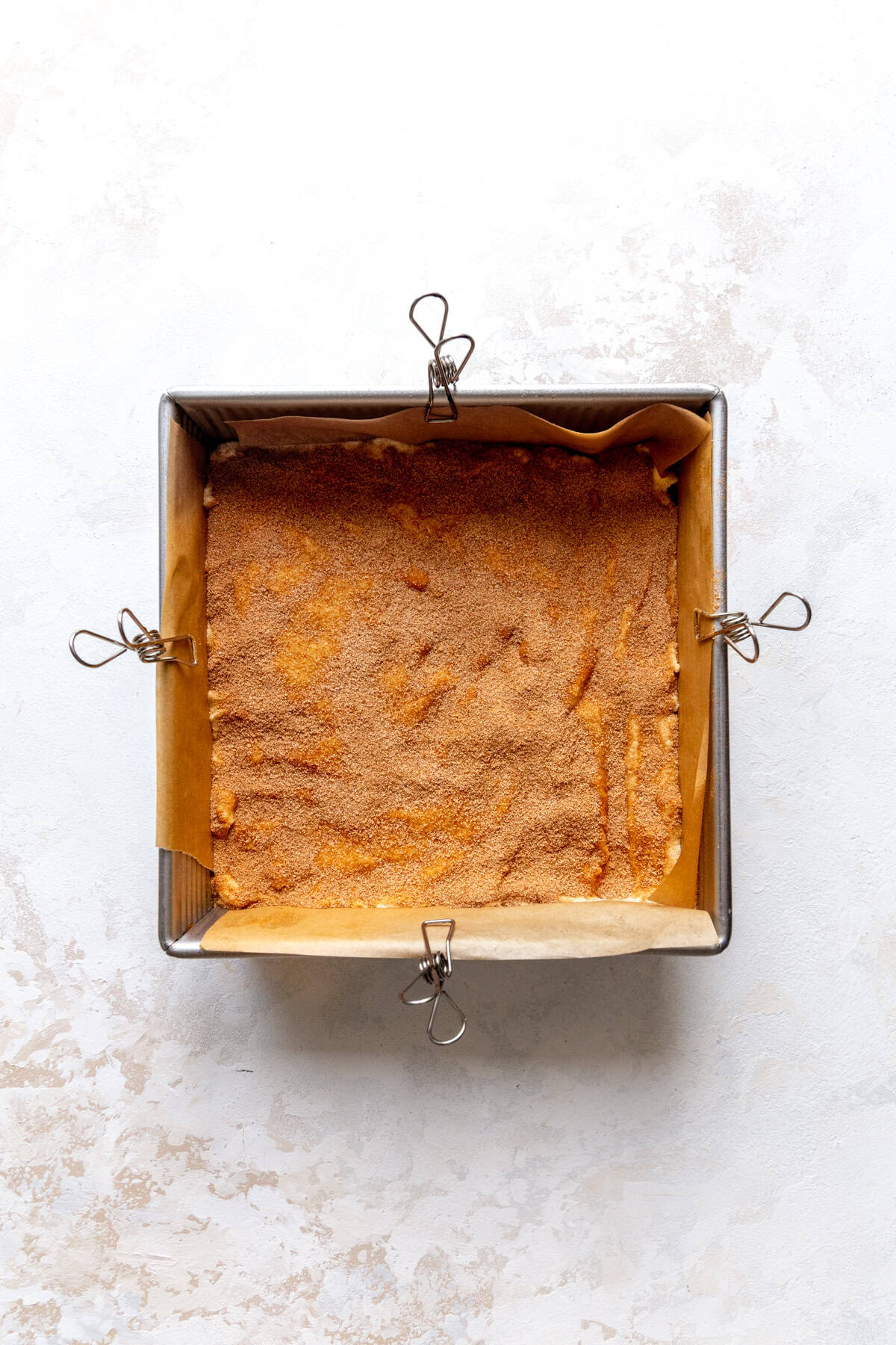 Unbaked snickerdoodle bars in a square pan.