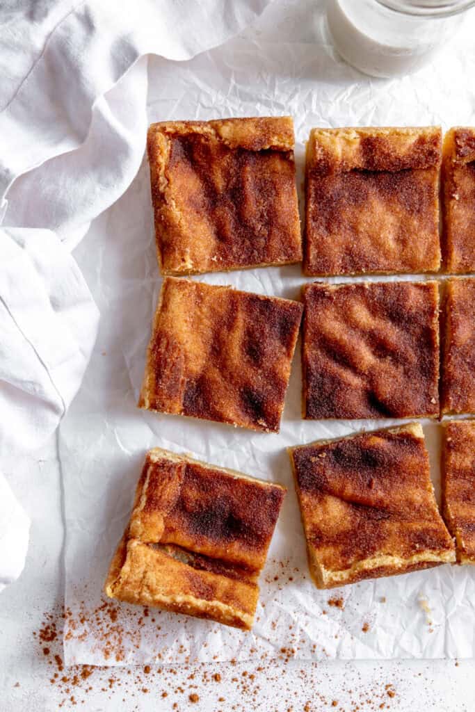 Snickerdoodle bars, a white linen napkin and a glass of milk.