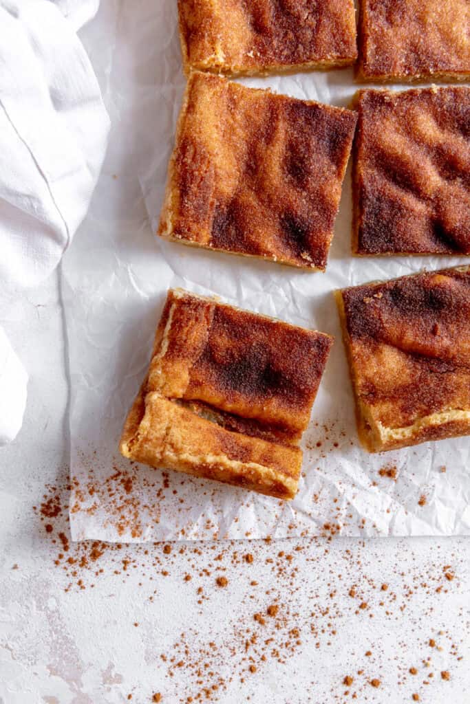 Snickerdoodle bars on a white surface and a linen napkin.