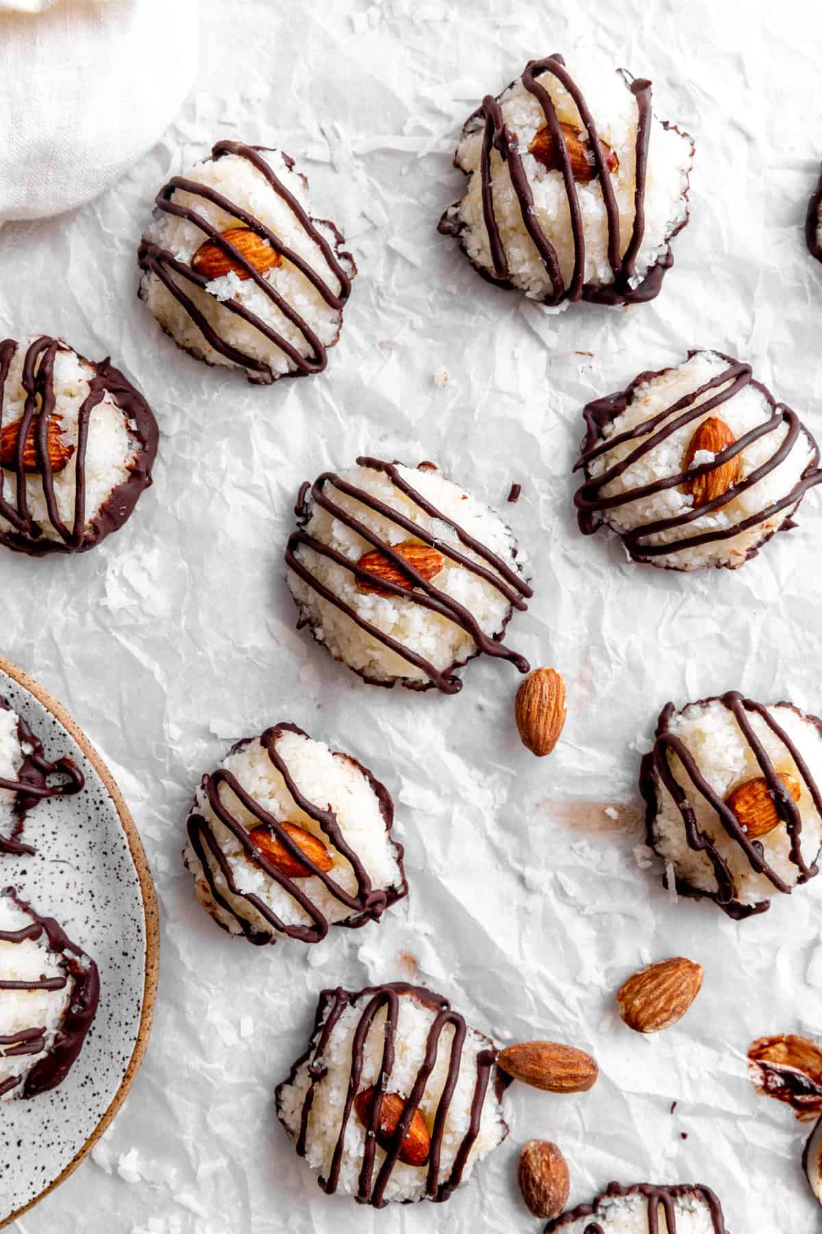 Vegan almond joy bites spread out on a white surface.