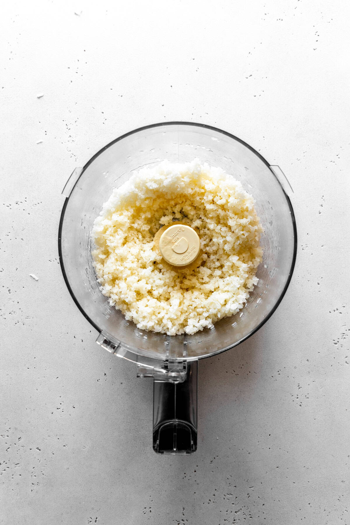 Food processor full of shredded coconut.