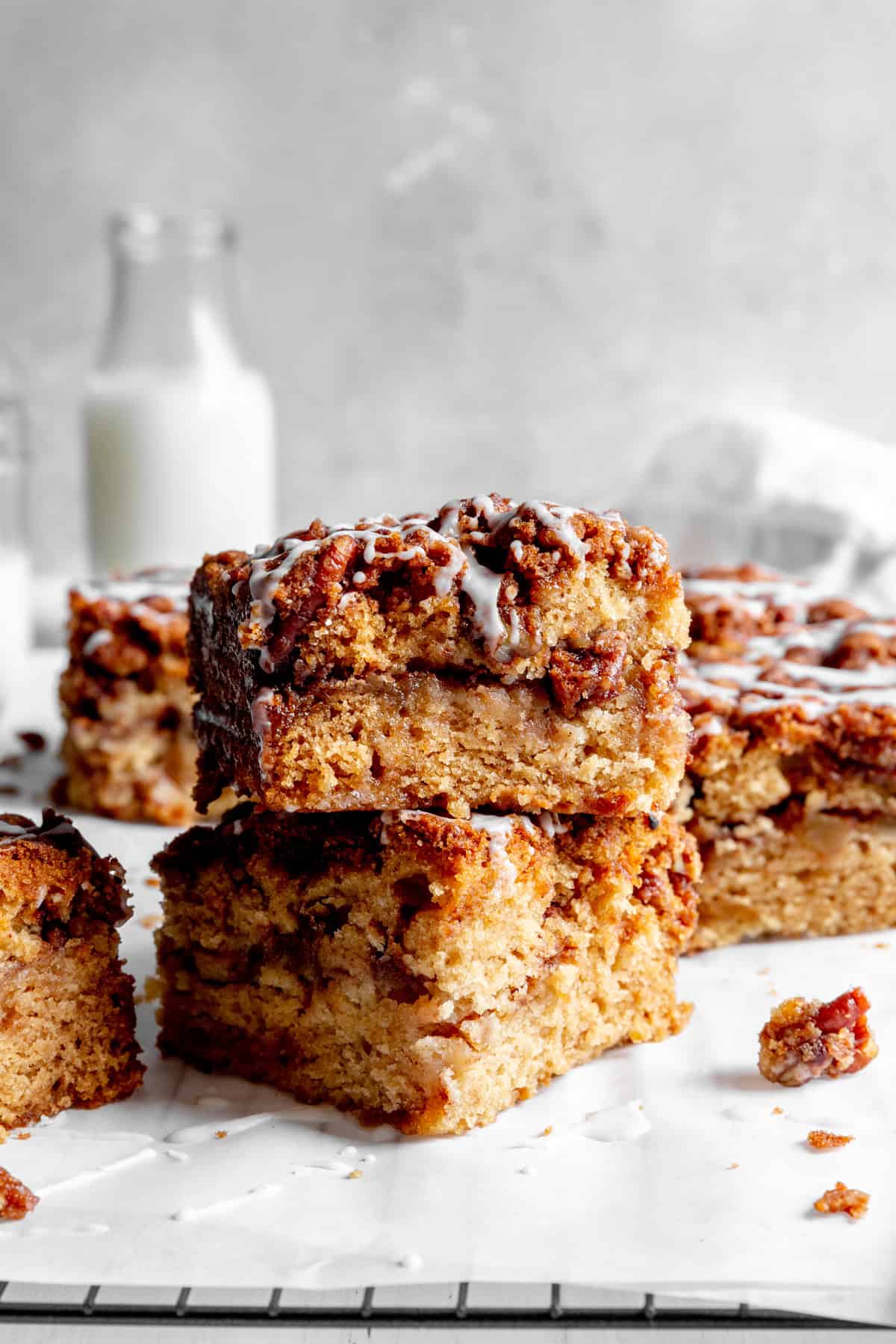Stacked slices of apple cinnamon coffee cake and a jug of milk.
