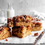 Stacked slices of apple cinnamon coffee cake and a jug of milk.