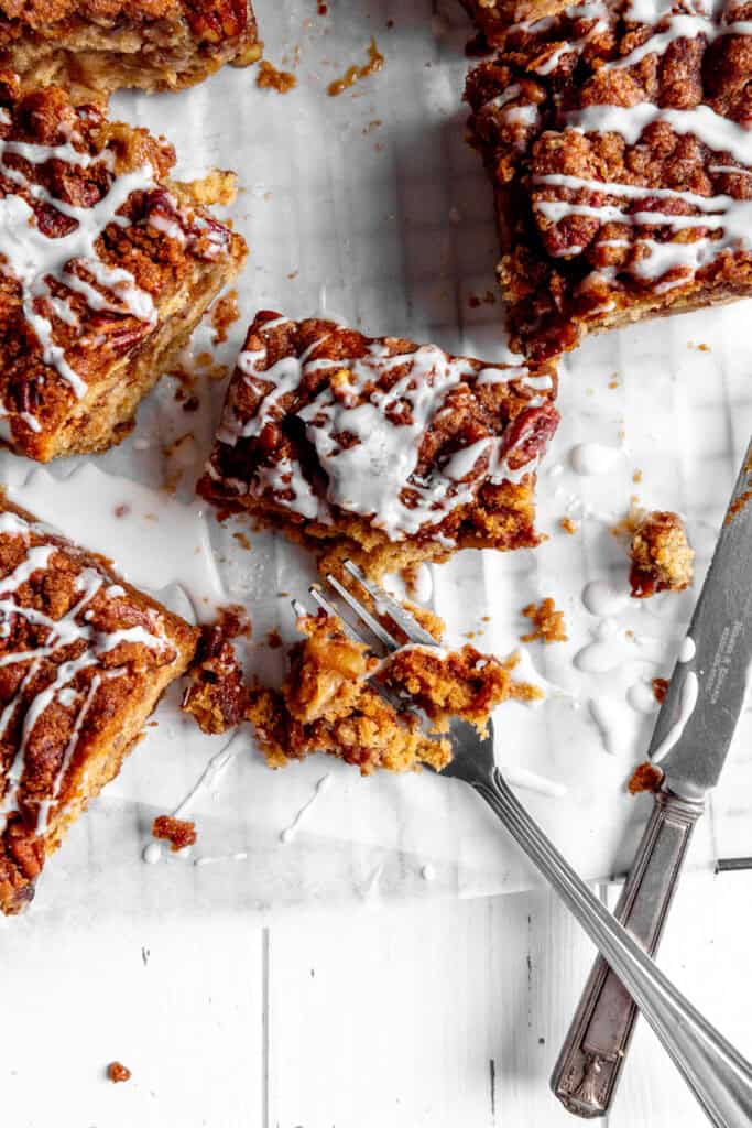 Half eaten piece of apple cinnamon coffee cake and a fork.