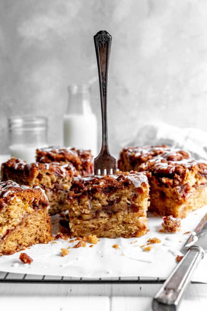 Fork stabbing into a piece of apple cinnamon coffee cake.