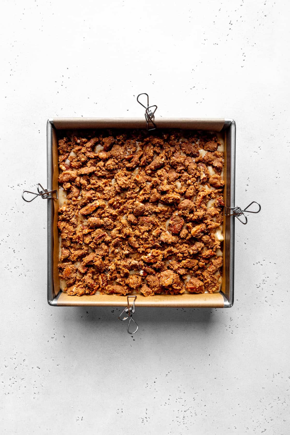 Unbaked apple cinnamon coffee cake topped with sugar and pecans.