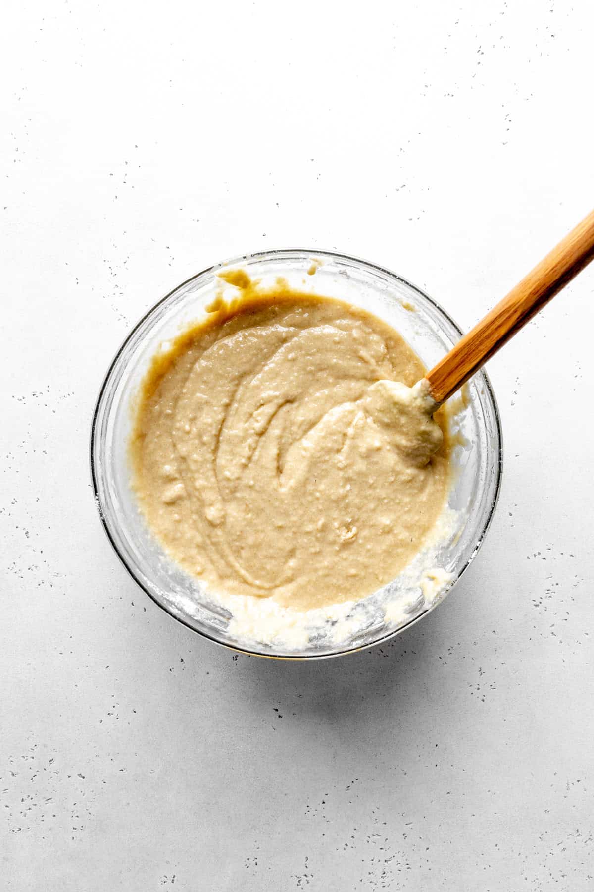 Coffee cake batter in a glass bowl with a rubber spatula.