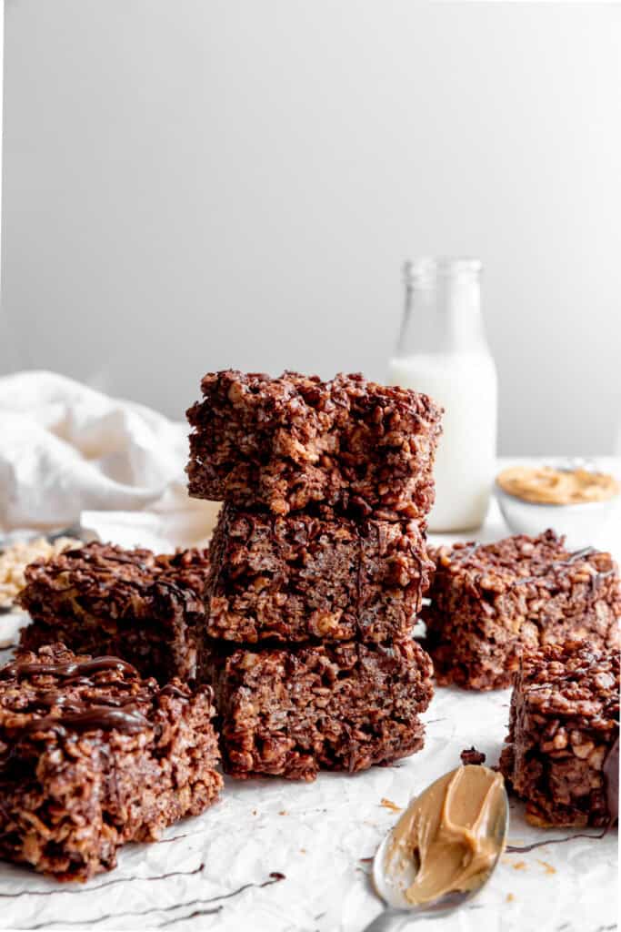 Stack of chocolate peanut butter rice krispie treats and a jug of milk.