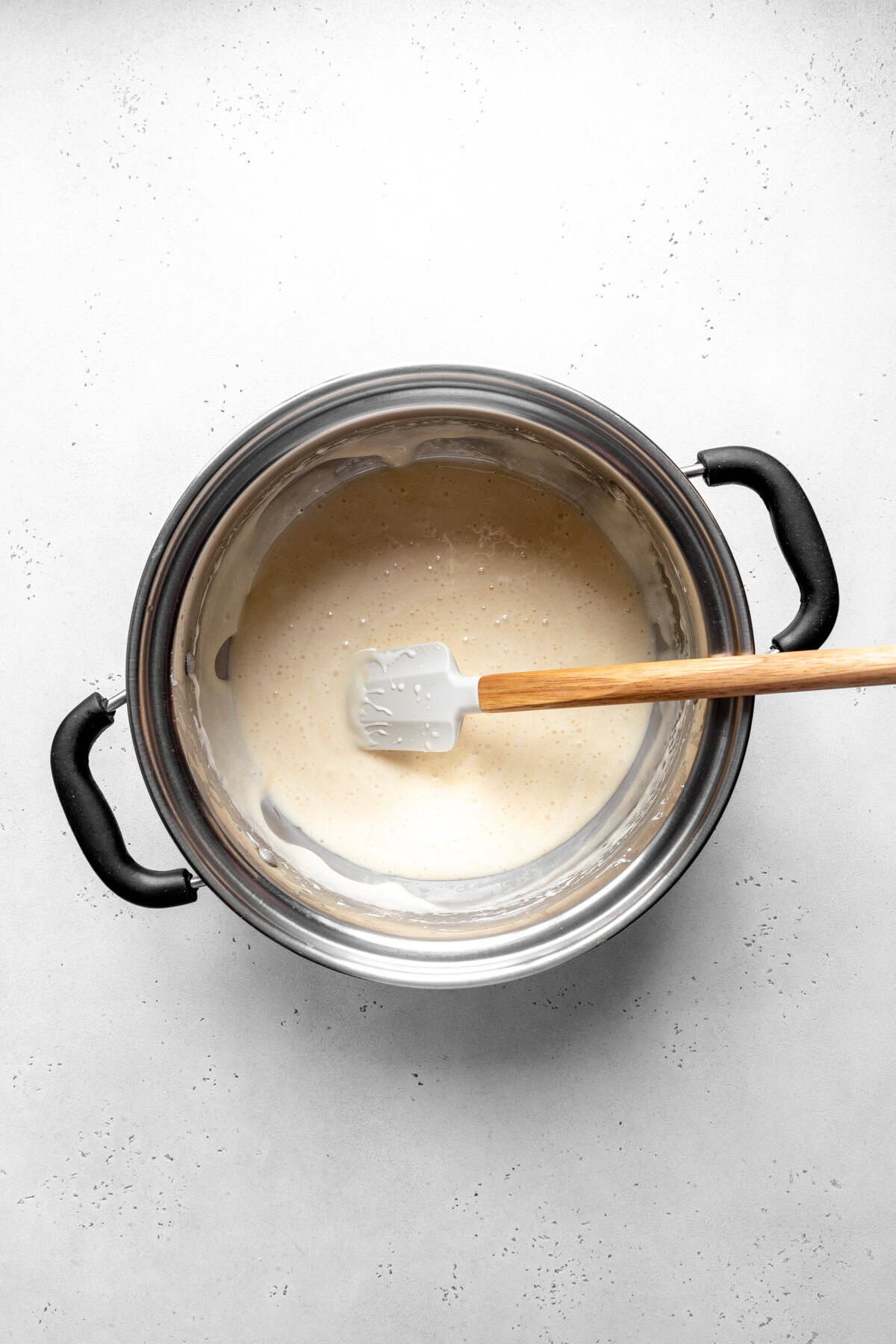 Melted marshmallows and butter in a pot with a rubber spatula.
