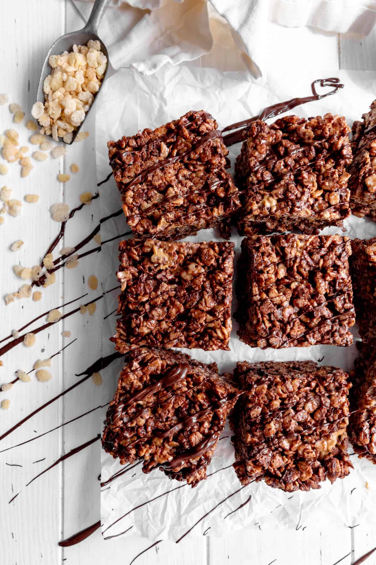 Chocolate peanut butter rice krispie treats and a scoop full of rice krispies.