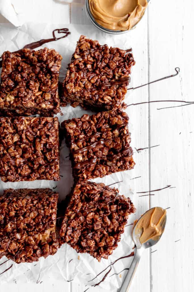 Chocolate peanut butter rice krispie treats and a spoon covered in peanut butter.