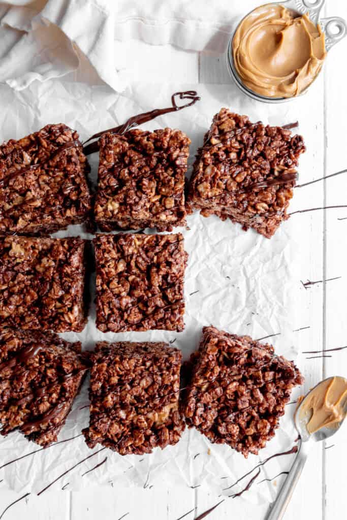 Chocolate peanut butter rice krispie treats and a cup of peanut butter.
