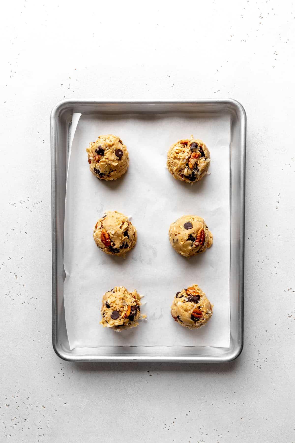 Unbaked cowboy cookies on a baking sheet.
