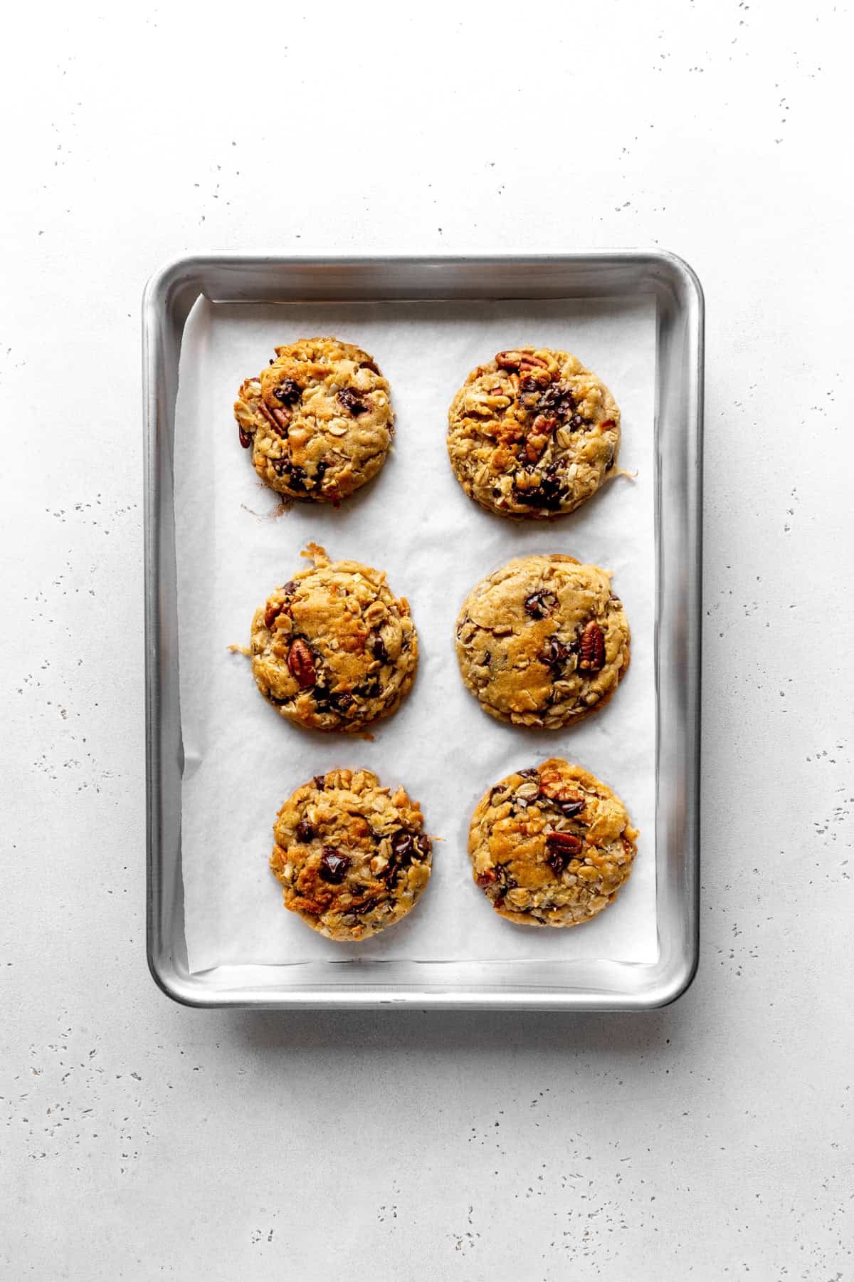 Baked cowboy cookies on a baking sheet.