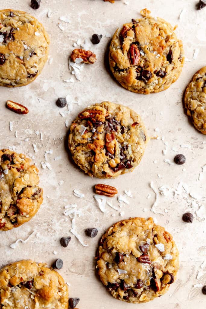 Cowboy cookies and scattered chocolate chips, pecans and coconut flakes.