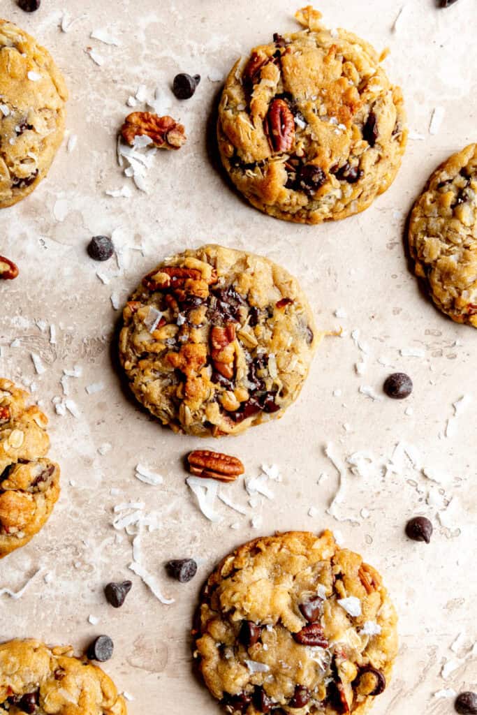 Cowboy cookies and scattered chocolate chips, pecans and coconut flakes.