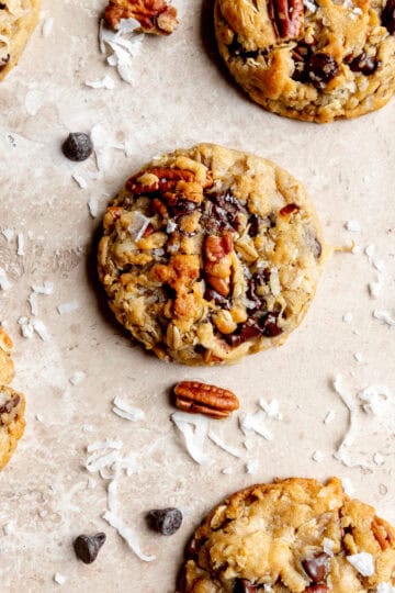 Cowboy cookies and scattered chocolate chips, pecans and coconut flakes.