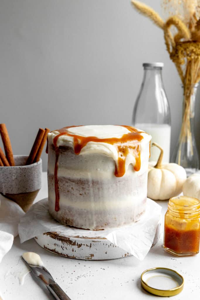 Pumpkin layer cake dripping with caramel sauce and a jug of milk.