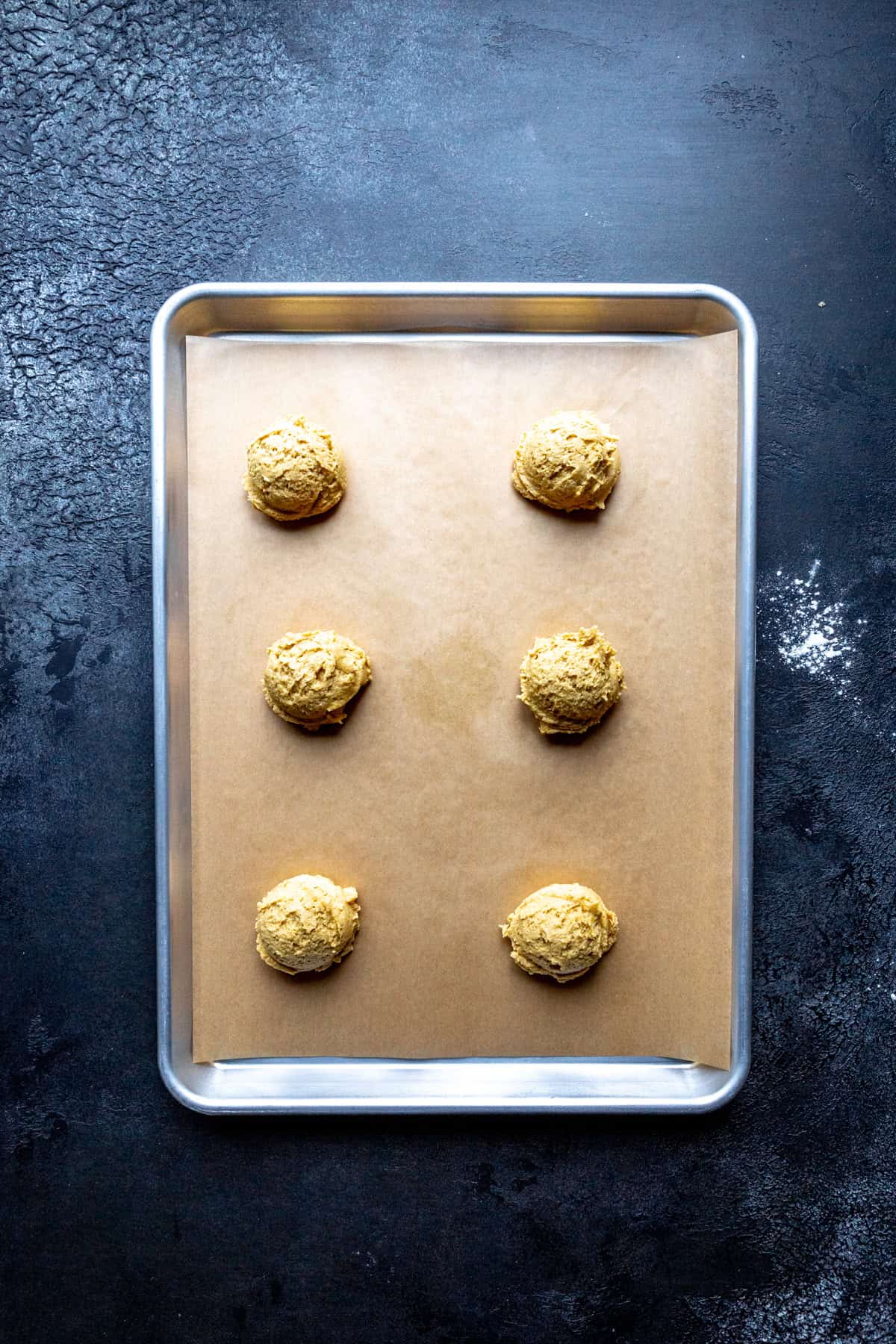 Unbaked pumpkin cookies on a baking sheet.