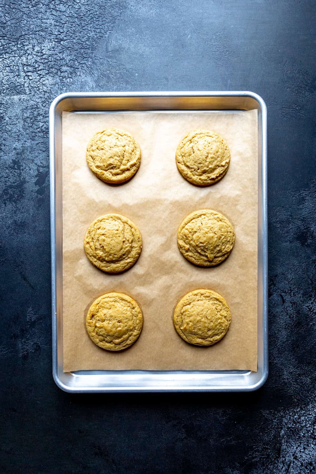 Baked pumpkin cookies on a baking sheet.