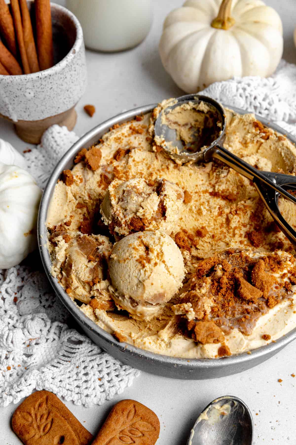 Scooped pumpkin spice ice cream and a cup of cinnamon sticks.