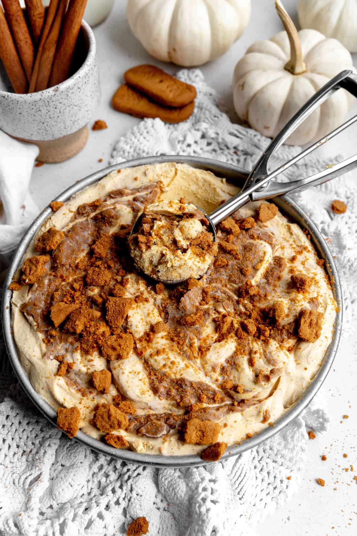 Ice cream scoop in a pan of pumpkin spice ice cream.