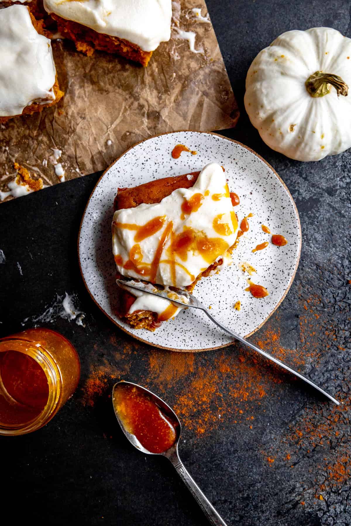 Fork cutting into a slice of salted caramel pumpkin cake.
