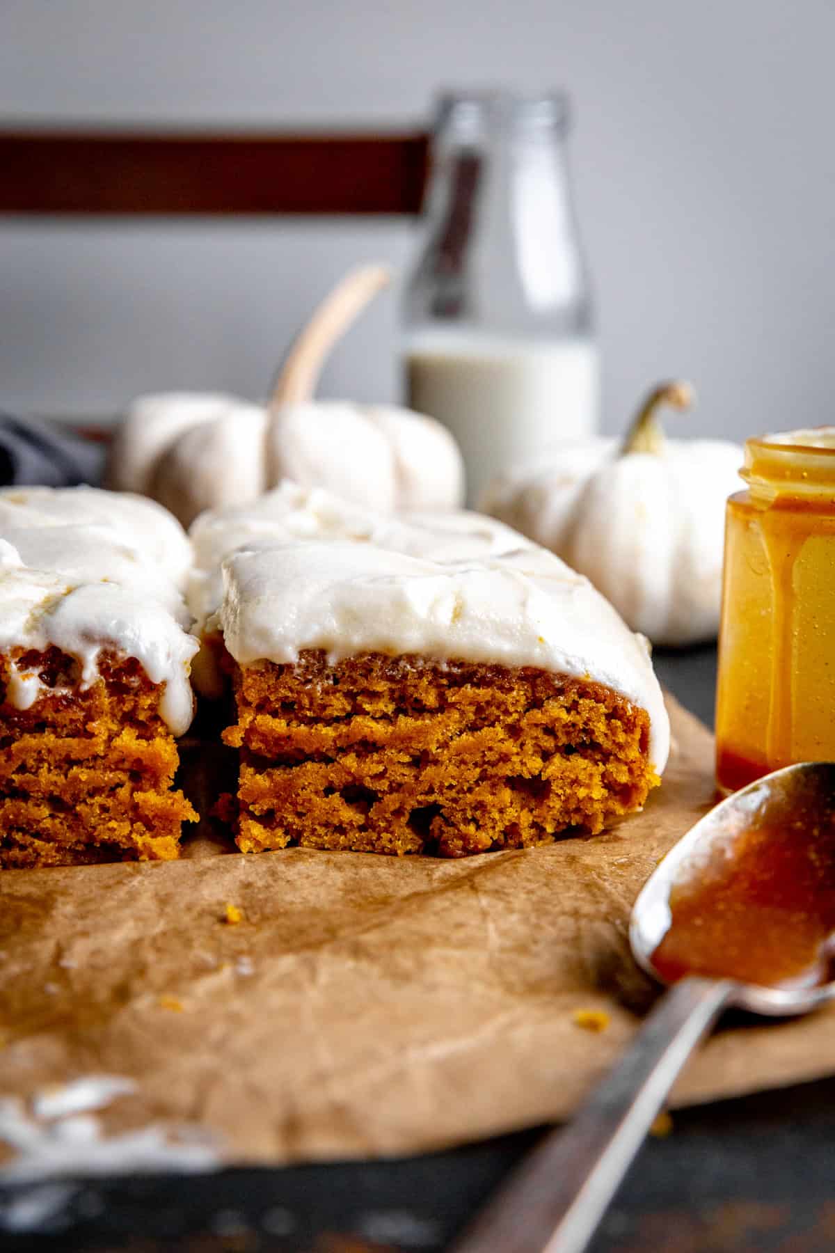 Frosted pumpkin cake slices and a jar of caramel sauce.