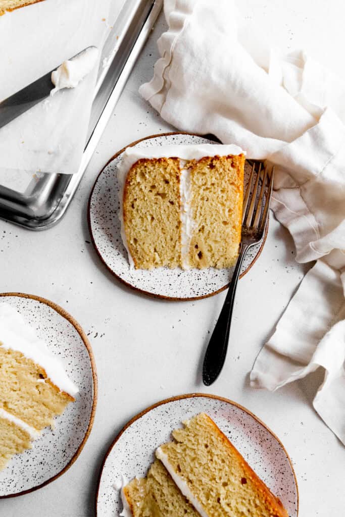 Slices of vanilla cake on white plates.