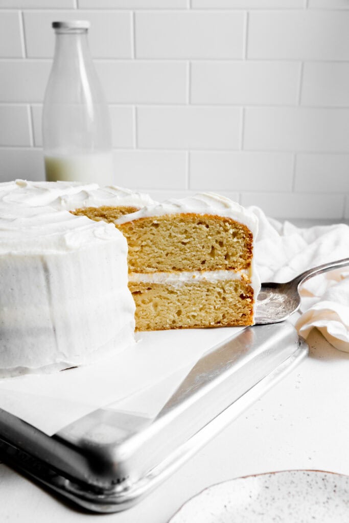 Cake spatula pulling out a slice of vanilla cake.