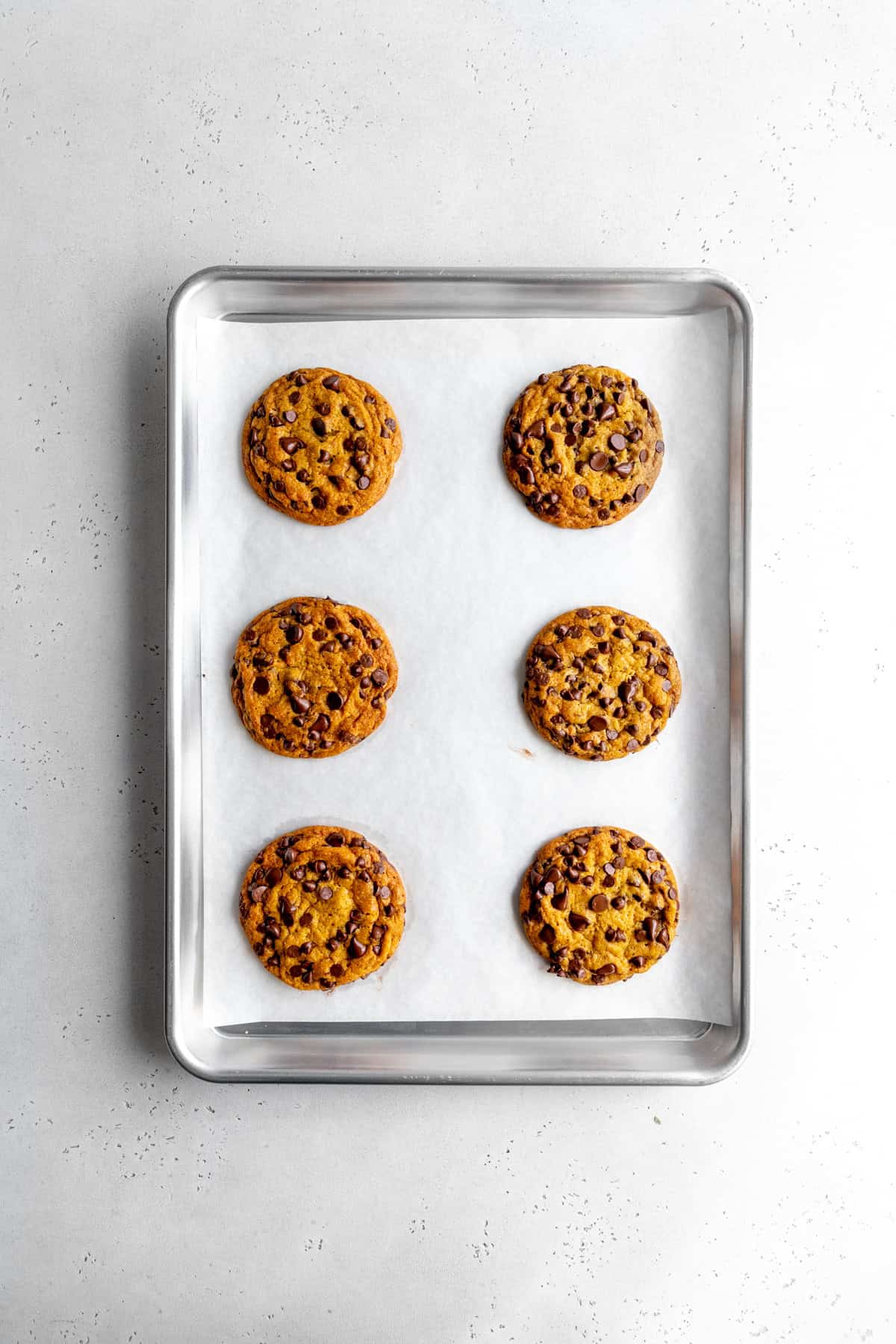 Baked pumpkin chocolate chip cookies on a baking sheet.