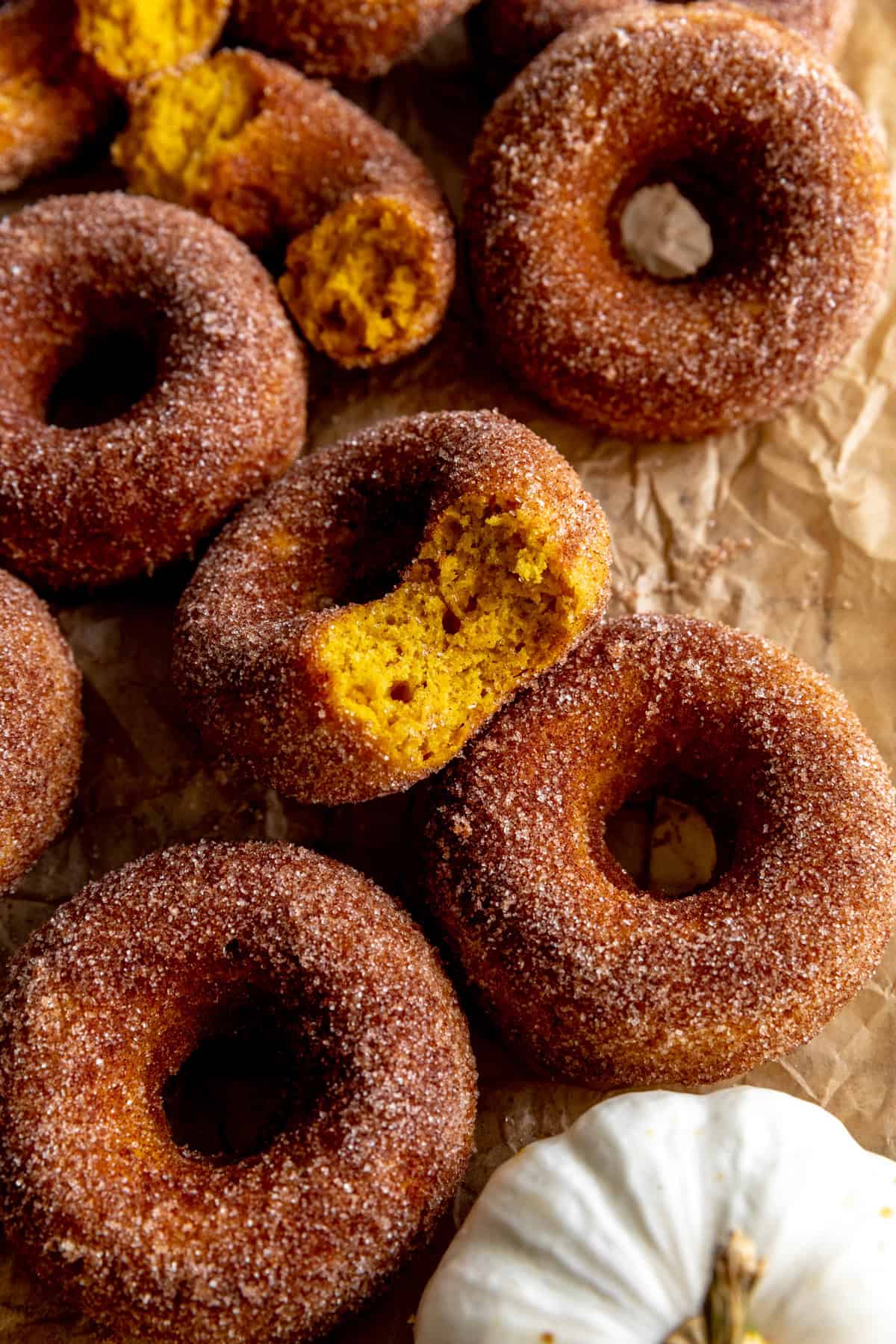 Pumpkin donut with a bite taken out of it.