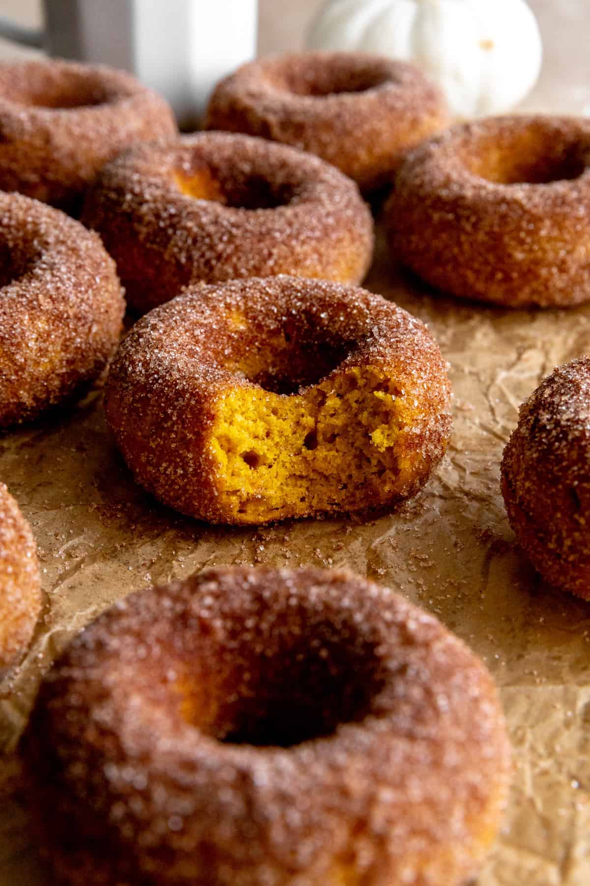 Pumpkin donut with a bite taken out of it.