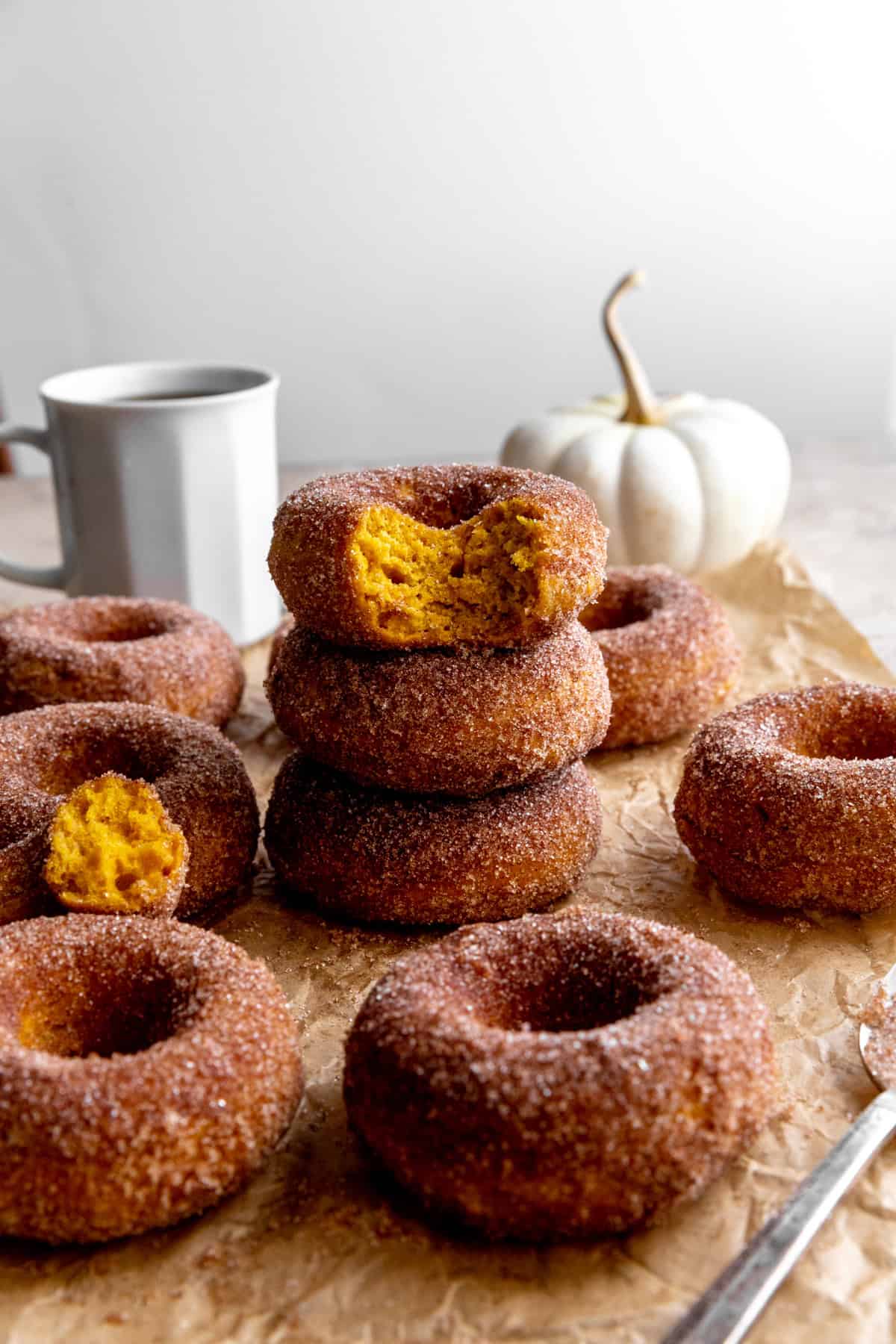 Stack of pumpkin donuts and a cup of coffee.