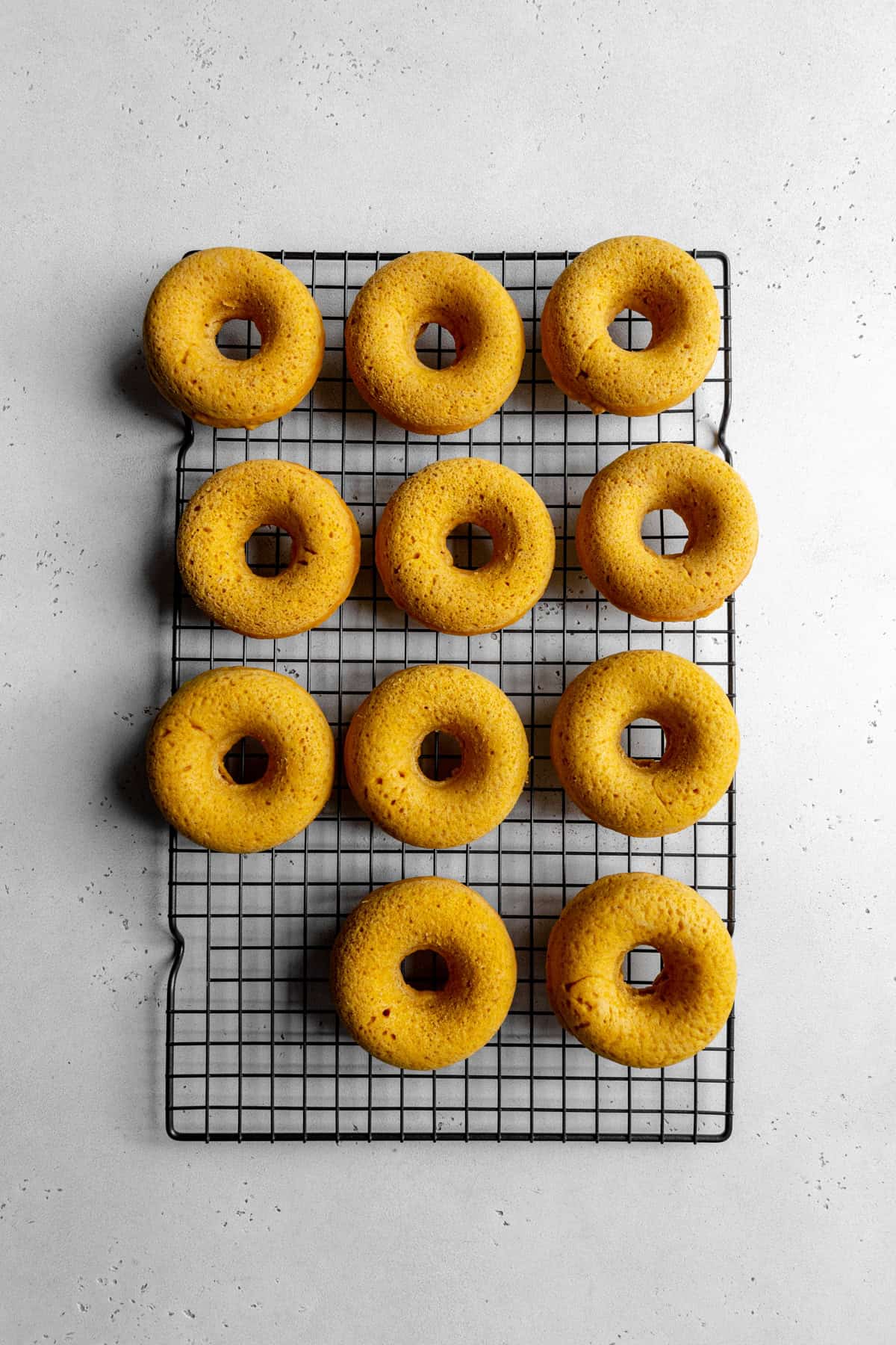 Baked donuts on a cooling rack.