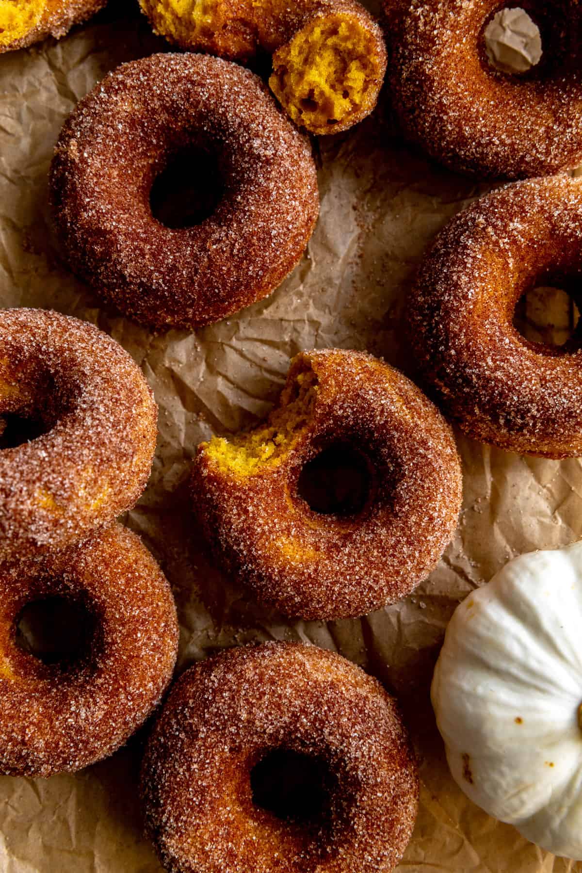 Pumpkin donut with a bite taken out of it.